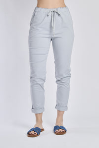 Pantaloni jogger grigi con coulisse, stile neutro, abbinati a sneaker bianche