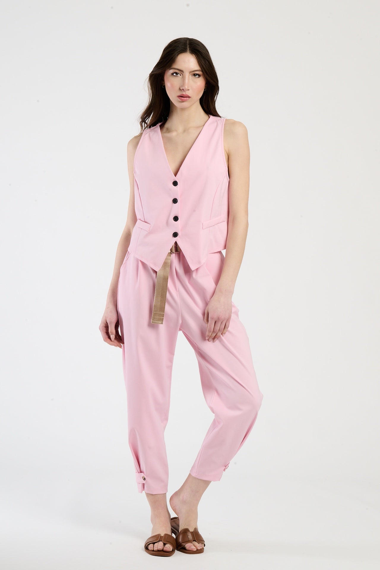 Donna con completo rosa: gilet e pantaloni, dolcezza e vivacità in un unico look.