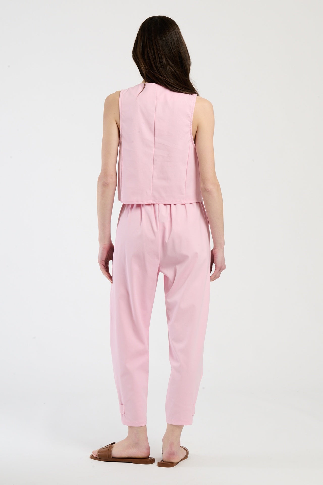 Completo rosa su una modella: gilet a bottoni e pantaloni, combinazione delicata e accattivante.