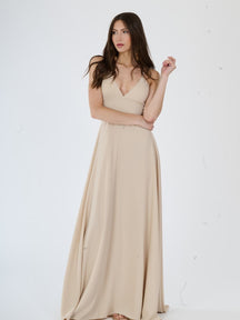 Abito lungo beige minimalista con spalline sottili, perfetto per un look elegante.