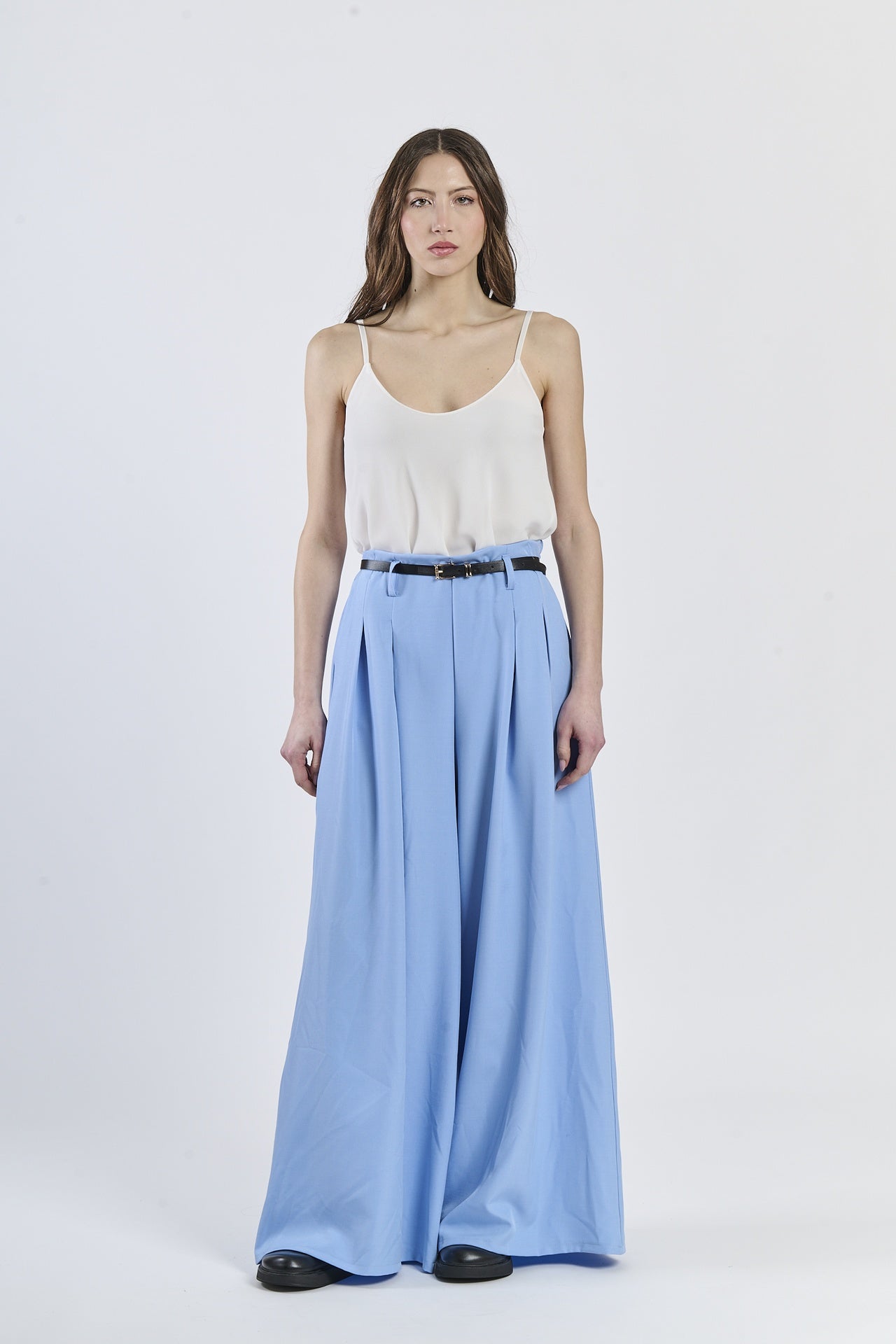 Look con top a bretelle sottili e pantaloni azzurri a gamba larga