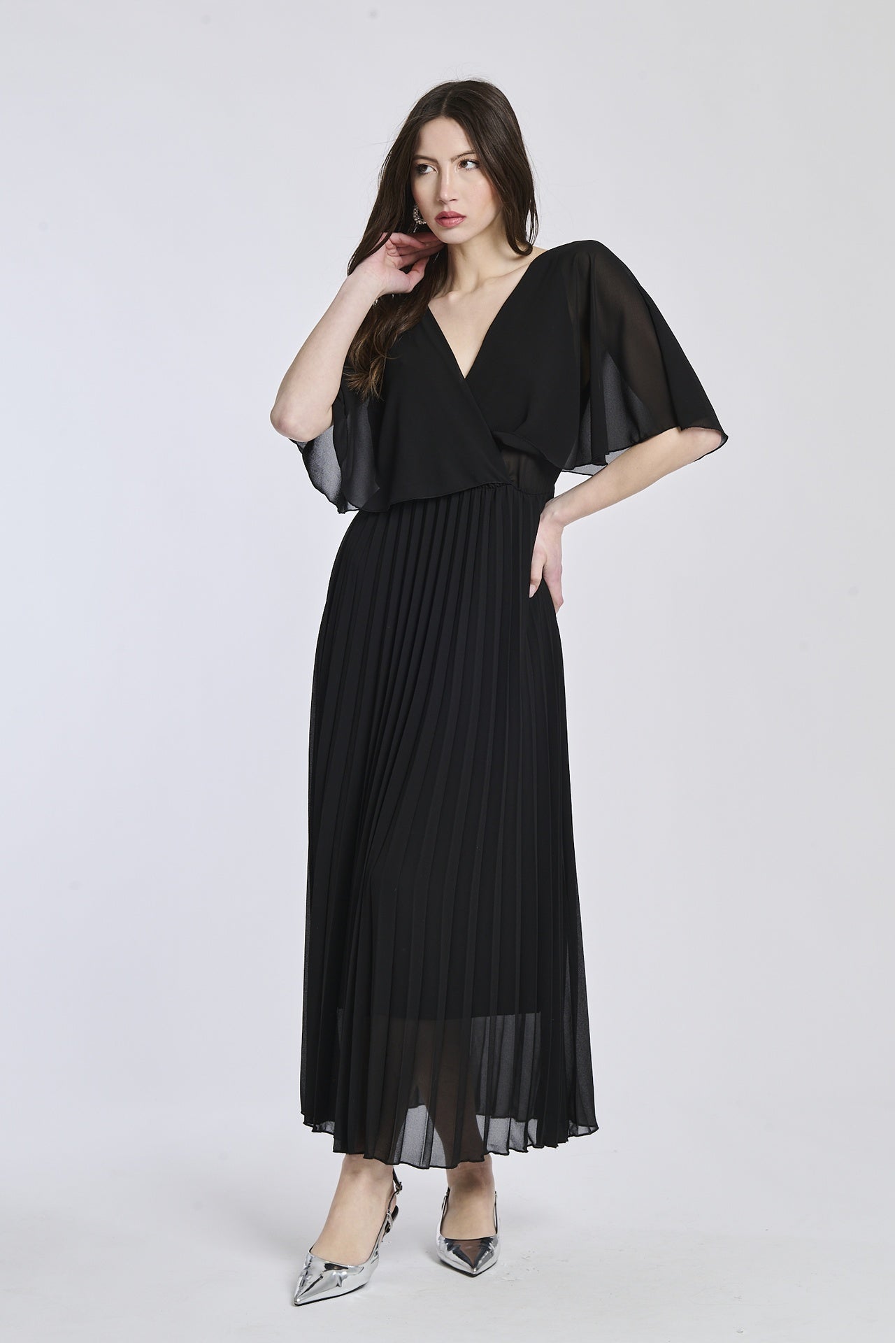 Un vestito in nero intenso, con la croce sul busto e le maniche a mantello come il modello mostrato, che dà un senso di mistero e sofisticazione.