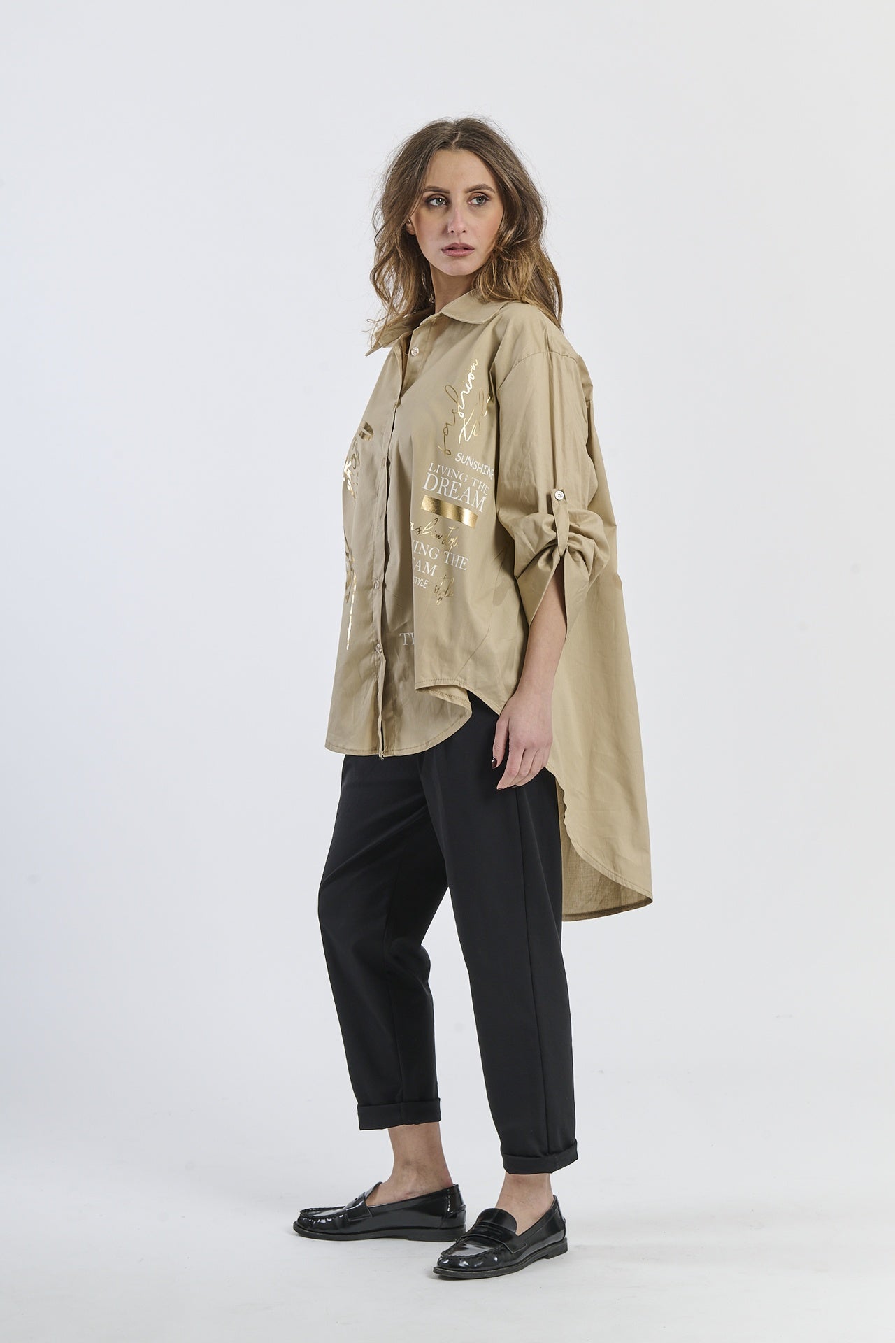 Outfit con camicia beige larga e pantaloni neri, scarpe mocassini