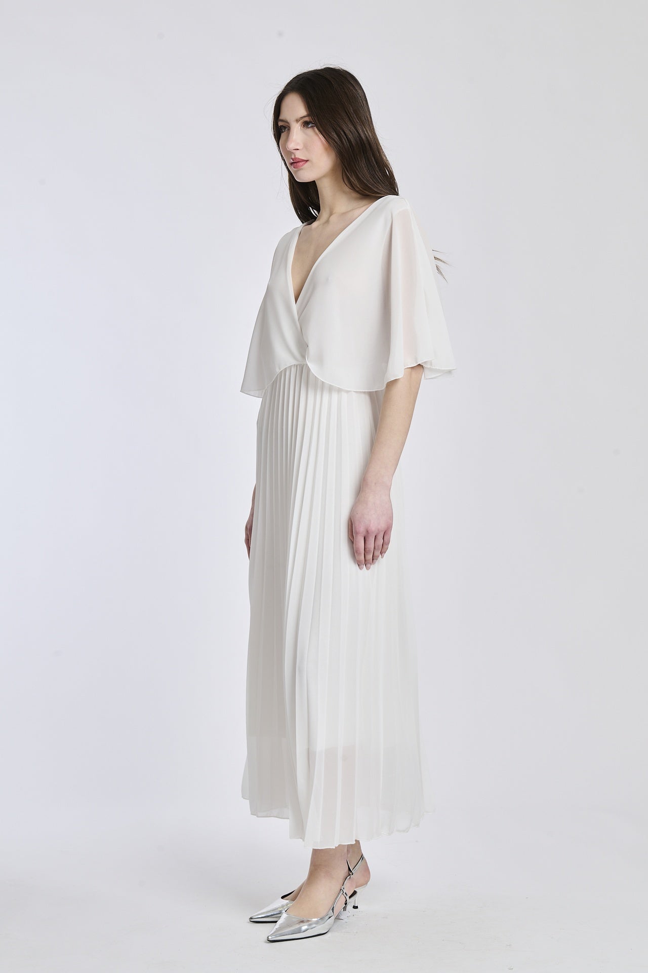 Vestito in bianco brillante con dettagli di falde e maniche, offrendo un look sofisticato e raffinato.