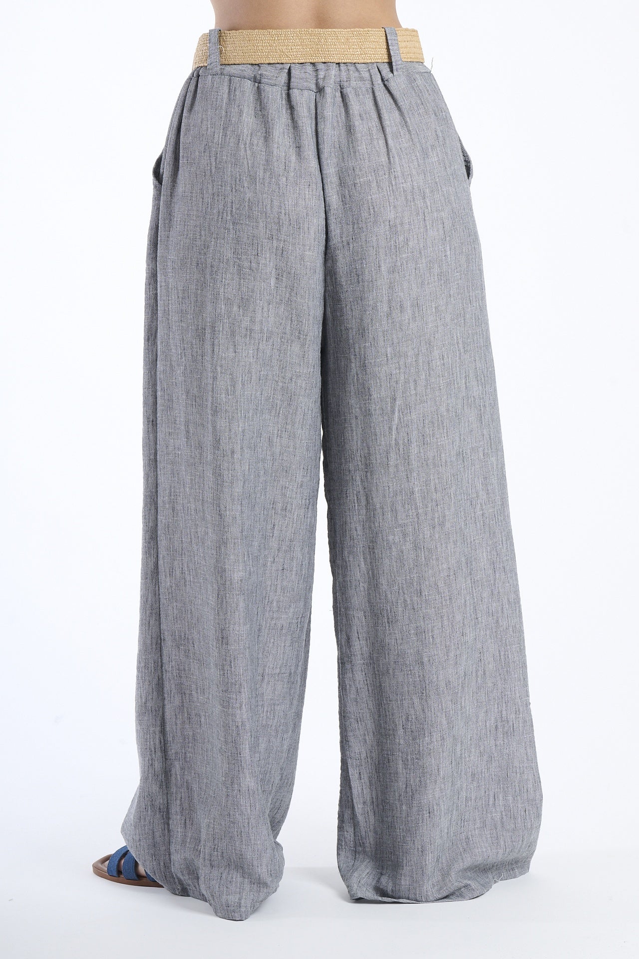 Modella indossa pantaloni neri larghi, stile classico e versatile.