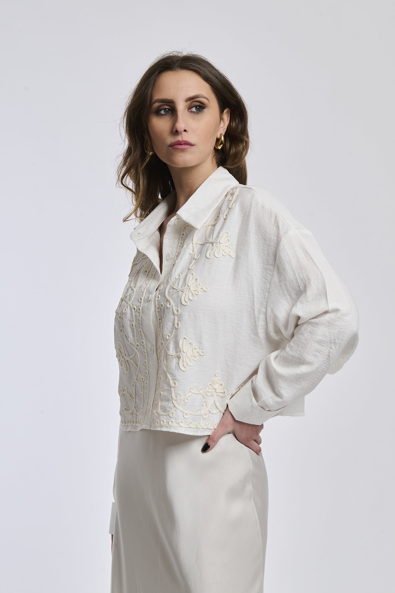 Camicia a righe blu e bianco indossata dalla donna, con colletto a V e bottoni in metallo,