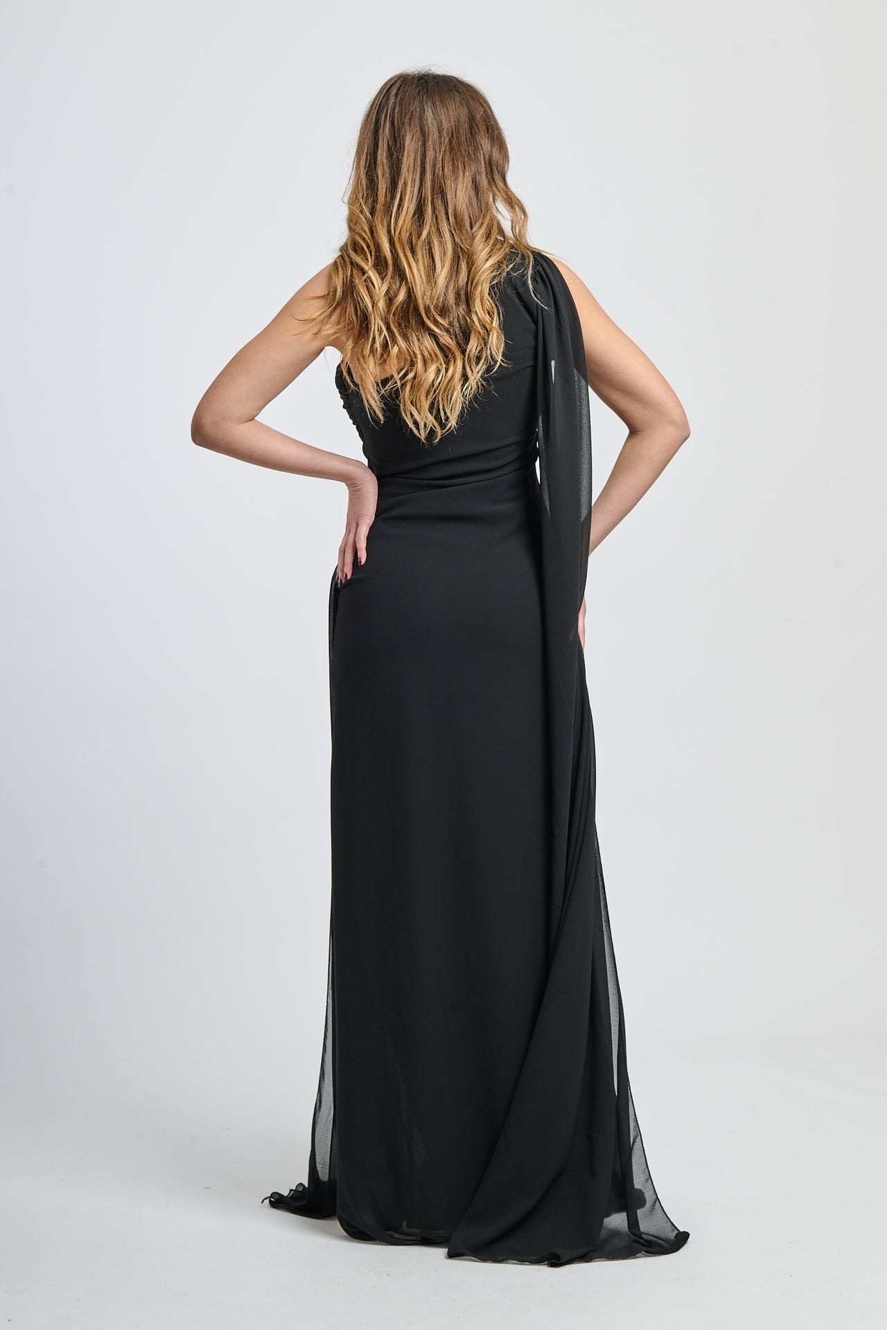 Abito da sera nero, tessuto leggero, silhouette allungata, colletto scollo spalla singola.