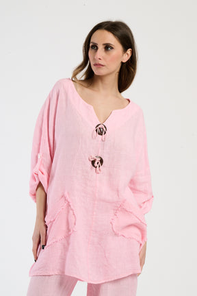 Outfit rosa in lino, camicetta oversize e pantaloni coordinati, stile pastello per l’estate.
