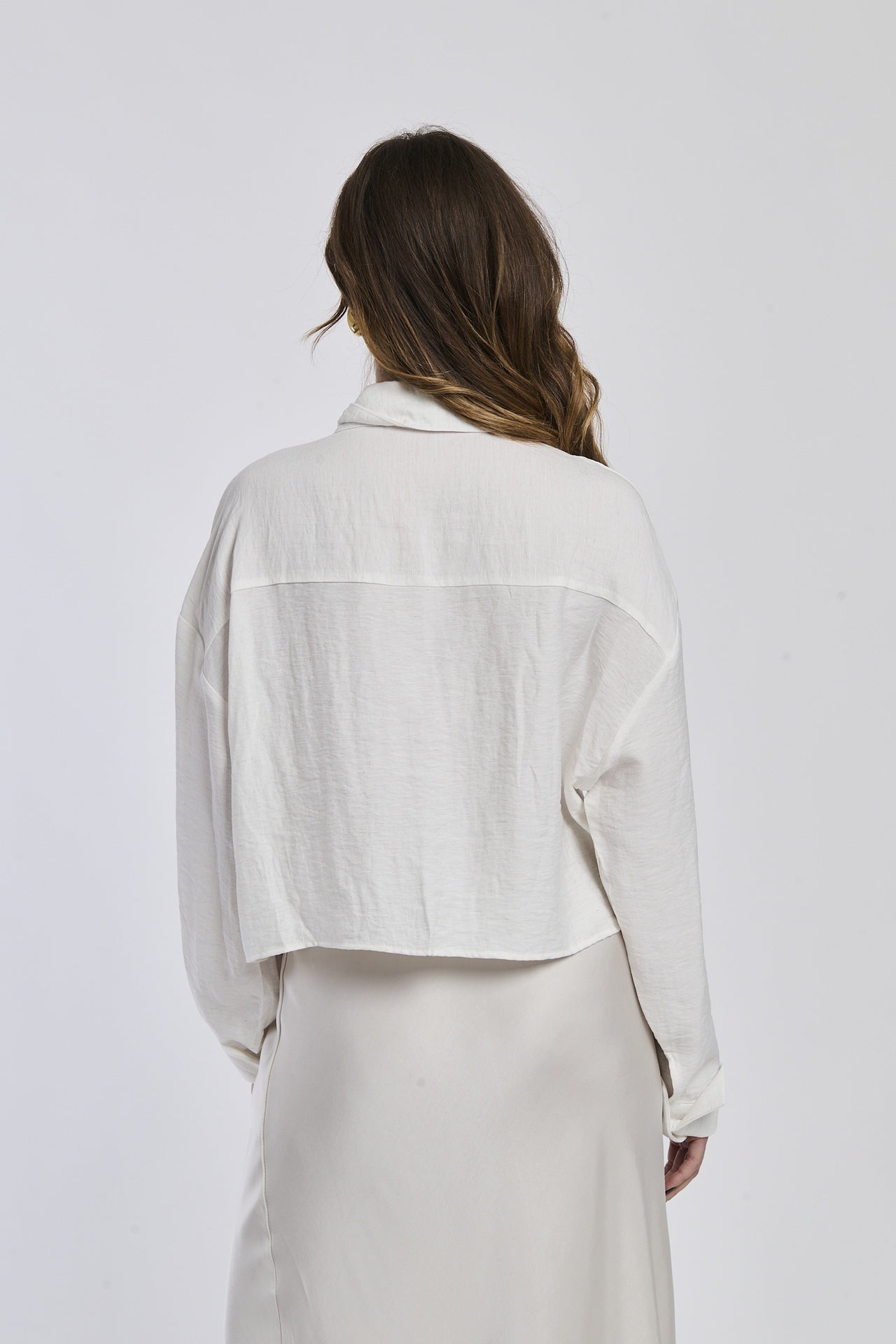 Donna veste una camicia a righe di un blu profondo e bianco, con un taglio leggermente oversize e maniche lunghe