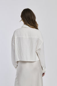 Donna veste una camicia a righe di un blu profondo e bianco, con un taglio leggermente oversize e maniche lunghe