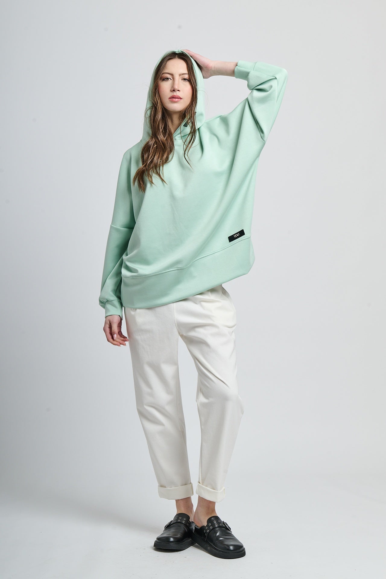 Outfit con felpa salvia con cappuccio e pantaloni neri, contrasto interessante