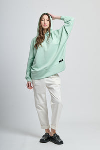 Outfit con felpa salvia con cappuccio e pantaloni neri, contrasto interessante