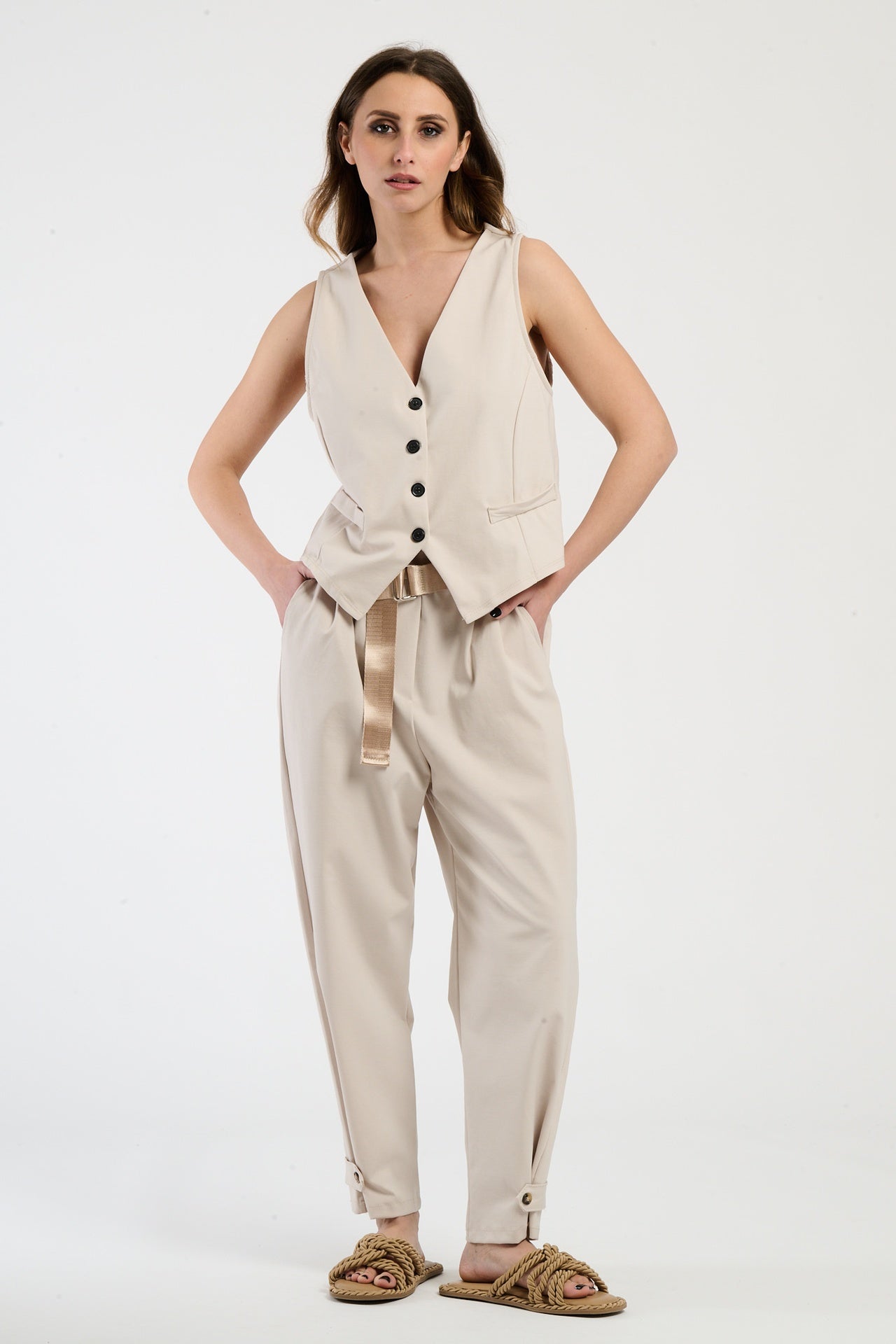 Outfit beige: gilet corto e pantaloni ampi, perfetto per un look naturale e confortevole.