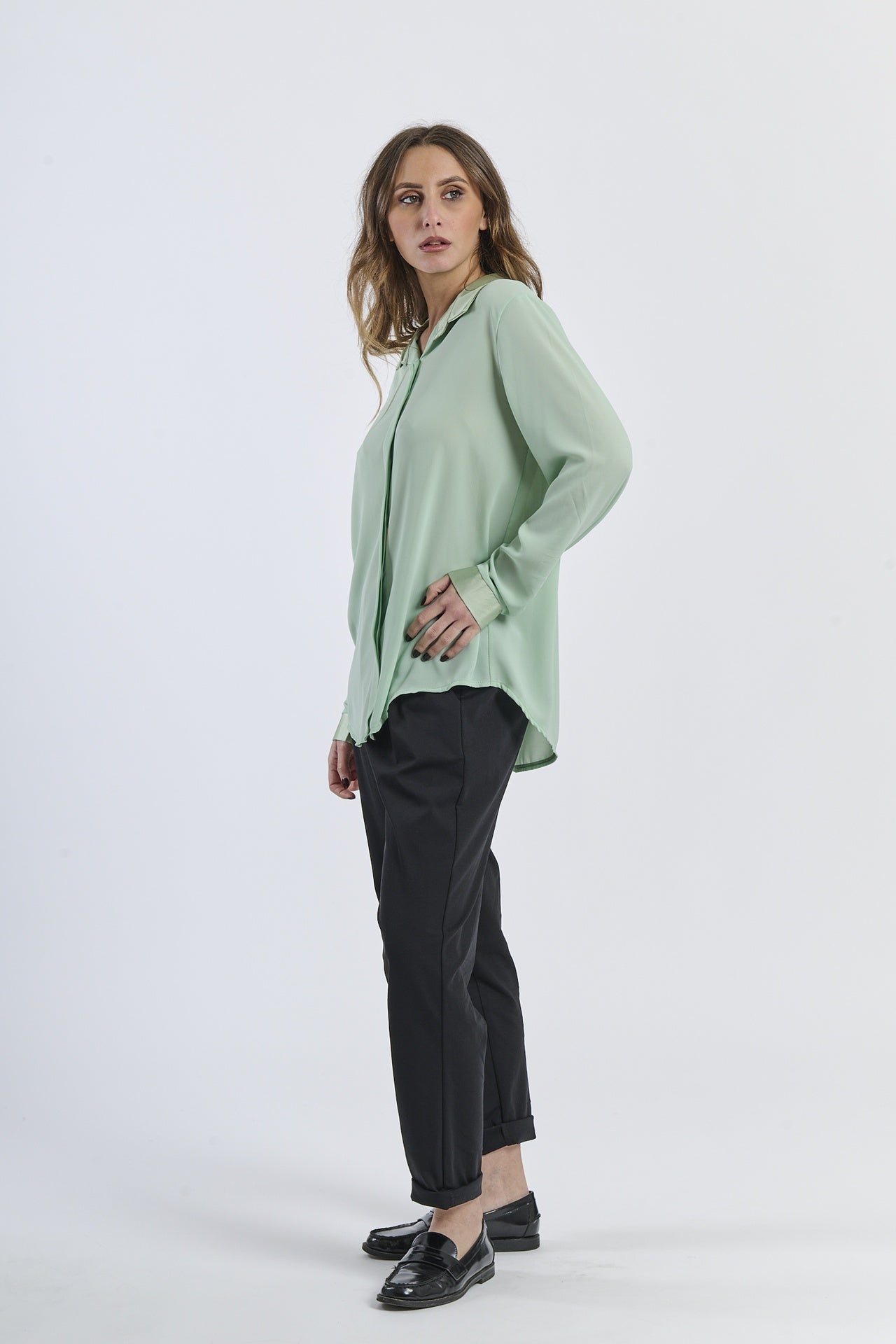 Outfit con camicia salvia e pantaloni neri, contrasto vegetale