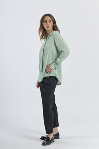 Outfit con camicia salvia e pantaloni neri, contrasto vegetale