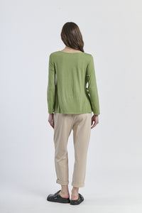 Blusa verde a maniche 3/4, abbinata a pantaloni neri, equilibrio cromatico
