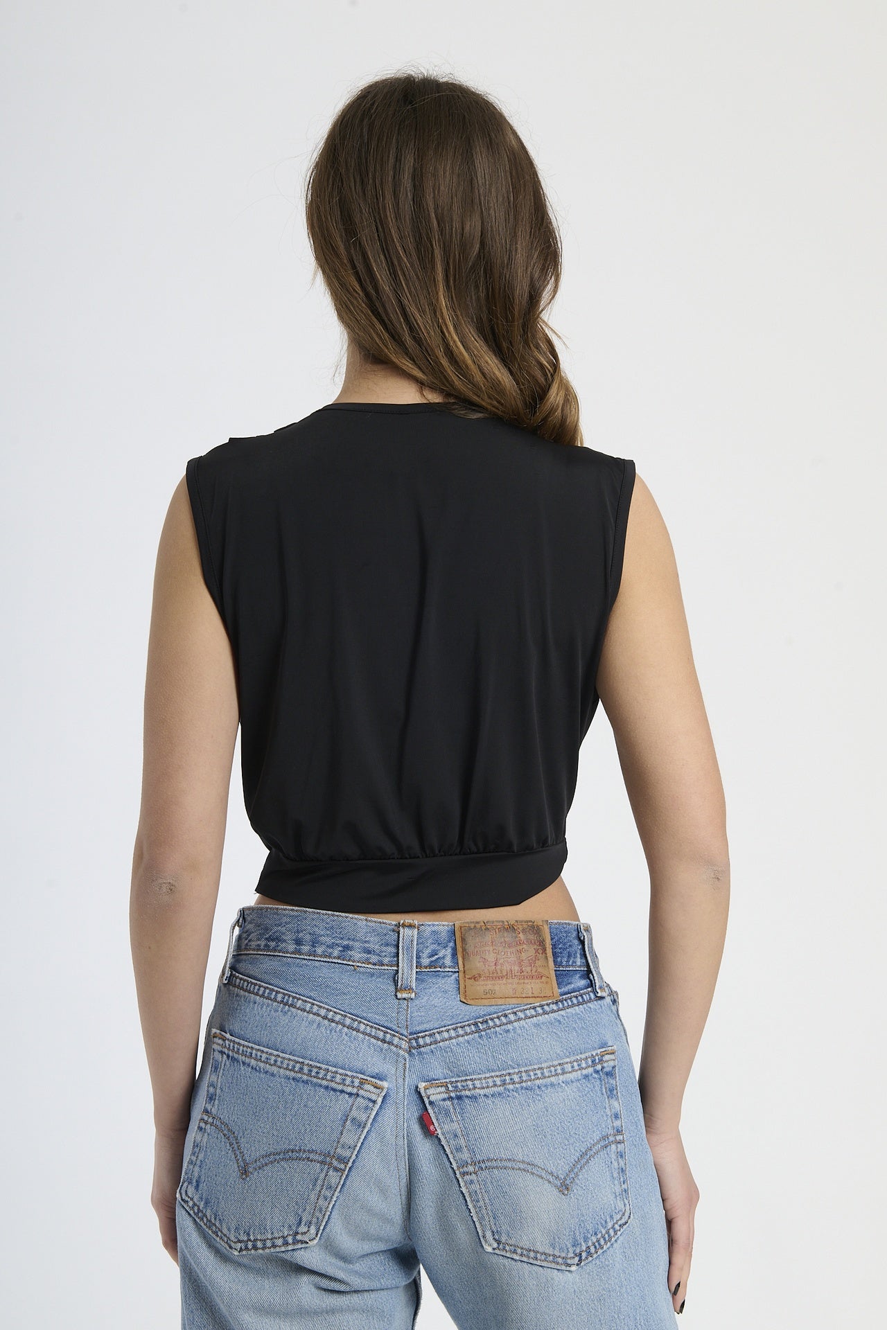 Canotta nera con scollatura a V, fibbia frontale e taglio cropped, classica ed elegante.