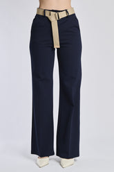Outfit di pantaloni bianchi con accessori: cintura navy e sandali blu