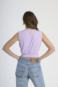 Maglia lilla senza maniche, design cropped con scollatura a V e fibbia decorativa.