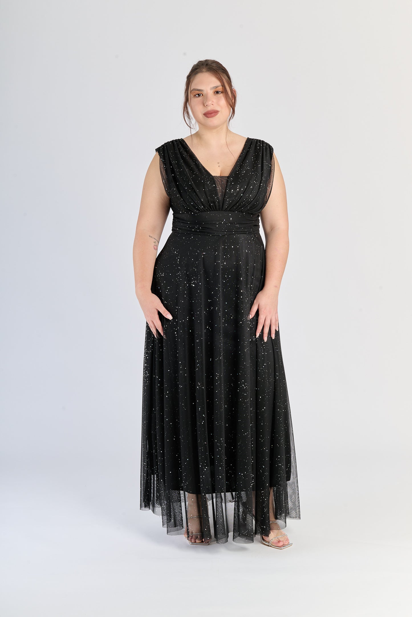 Abito nero da cerimonia, colletto a V e gonna fluviale, eleganza assoluta.