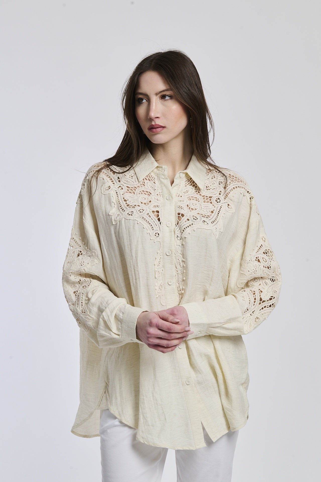 Donna indossa una camicia blu scuro con maniche lunghe e colletto a V, esprimendo un’aria di profondità e mistero.