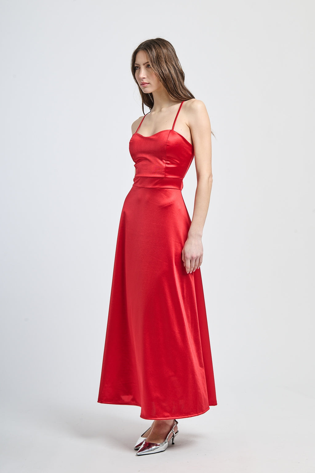 Abito formale rosso con taglio fluido, spalline sottili e finitura drammatica, adatto per serate notturne e iconiche