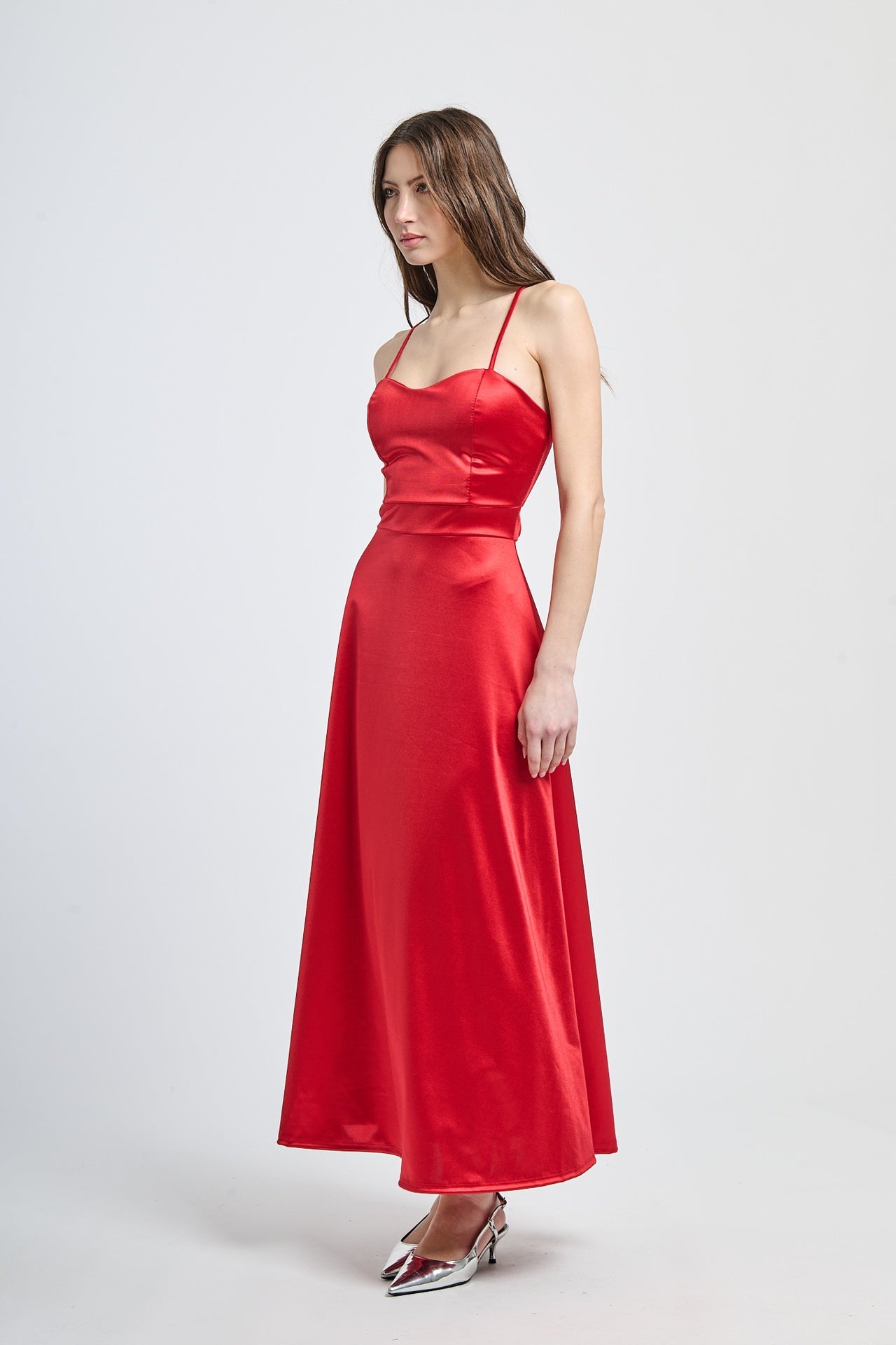 Abito formale rosso con taglio fluido, spalline sottili e finitura drammatica, adatto per serate notturne e iconiche