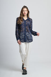 Camicetta navy con motivi, collo camiciera e maniche lunghe, abbinata a pantaloni neri.