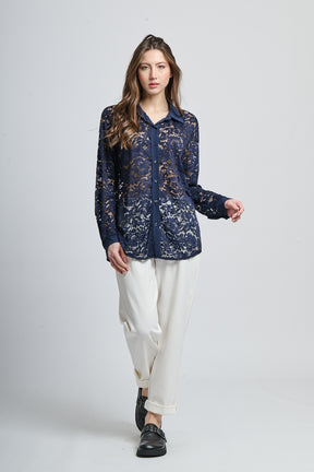 Camicetta navy con motivi, collo camiciera e maniche lunghe, abbinata a pantaloni neri.