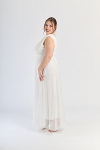 Abito bianco da cerimonia, colletto a V e gonna fluviale, purezza ed eleganza.