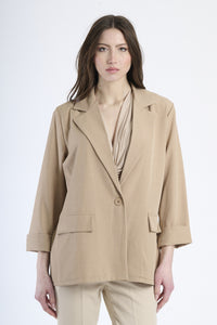 Blazer tabacco su figura, esempio di moda retrò e accesa.