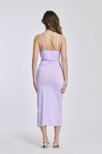 Abito lilla a spalline sottili, tessuto leggero e apertura laterale per uno stile delicato e affascinante.