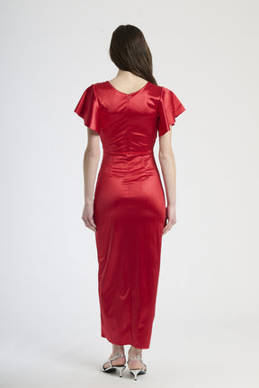 Modella indossa abito rosso a scollatura V, stile audace per serate glamour.