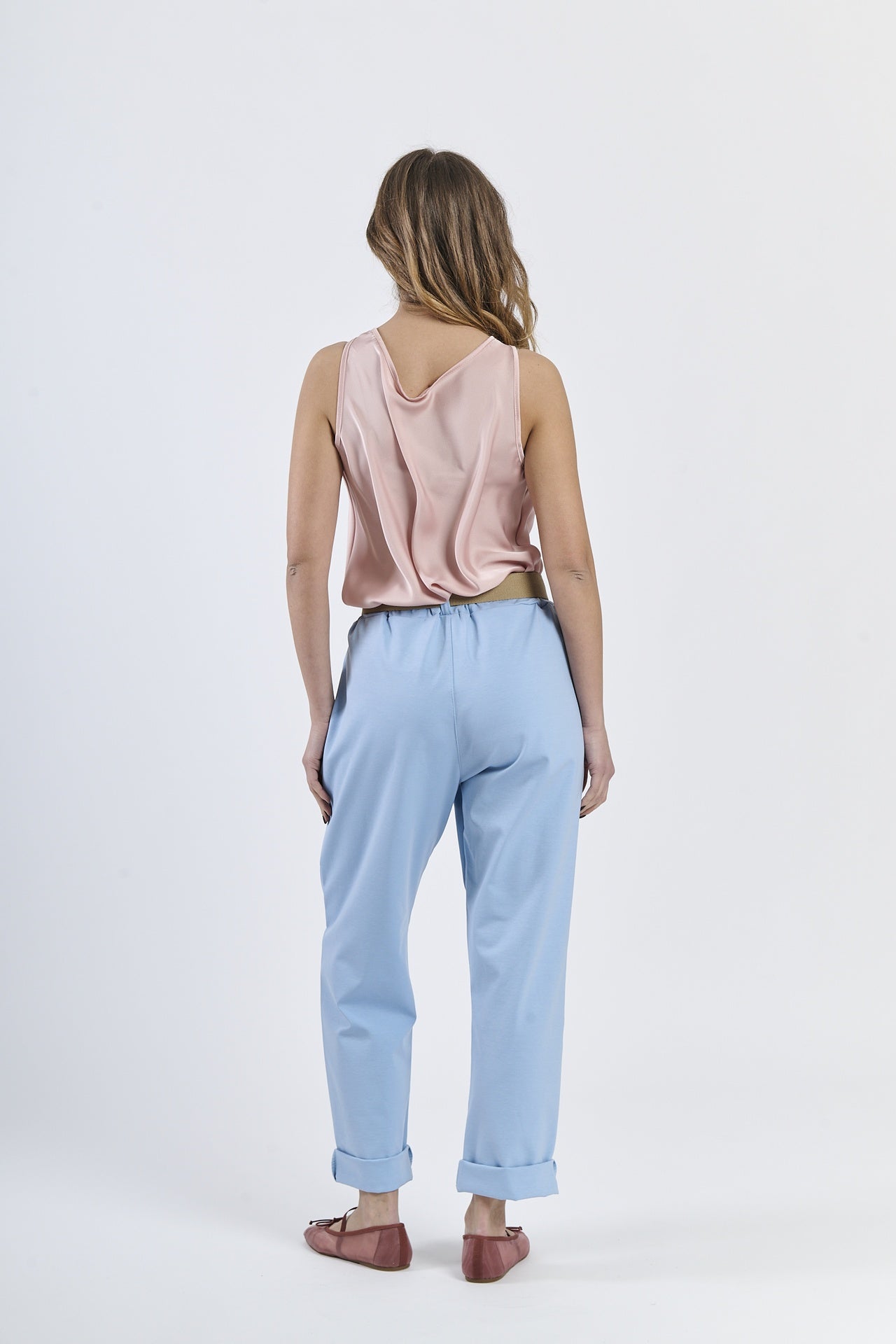 Combinazione top satinato rosa e pantaloni azzurri chiari, stile casual-elegante