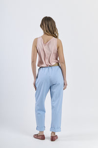 Combinazione top satinato rosa e pantaloni azzurri chiari, stile casual-elegante