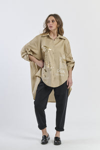 Camicia beige oversize con dettagli stilizzati, look urbano