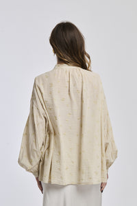 Camicia beige in tessuto leggero, design retrò, ideale per un’atmosfera calda e accogliente.