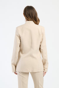 Donna indossa una camicia beige aderente con dettagli in seta.