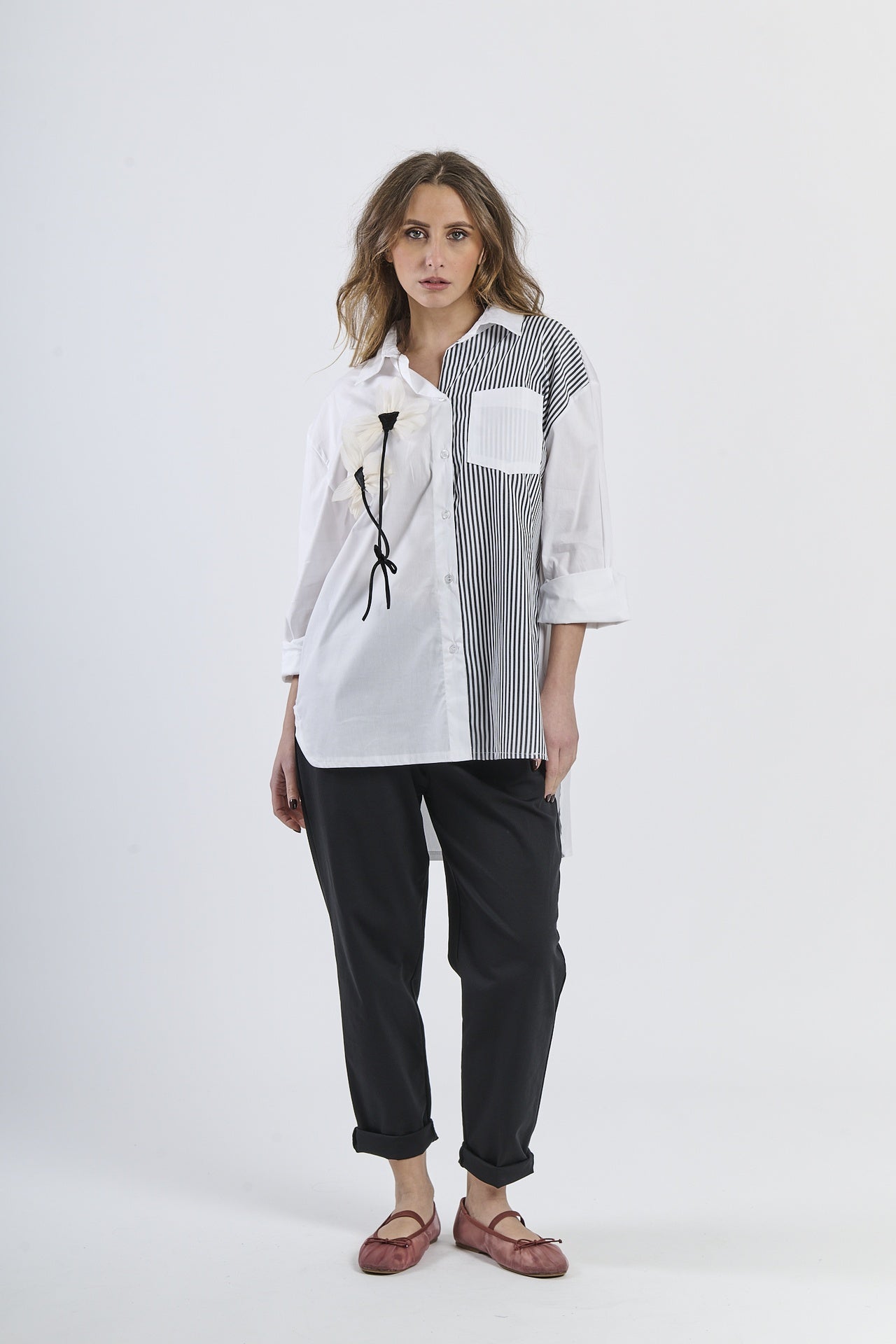 Look fashion con camicia nero  bicolor a righe, colletto classico, maniche a 3/4 e decorazione floreale, abbinata a pantaloni scuri