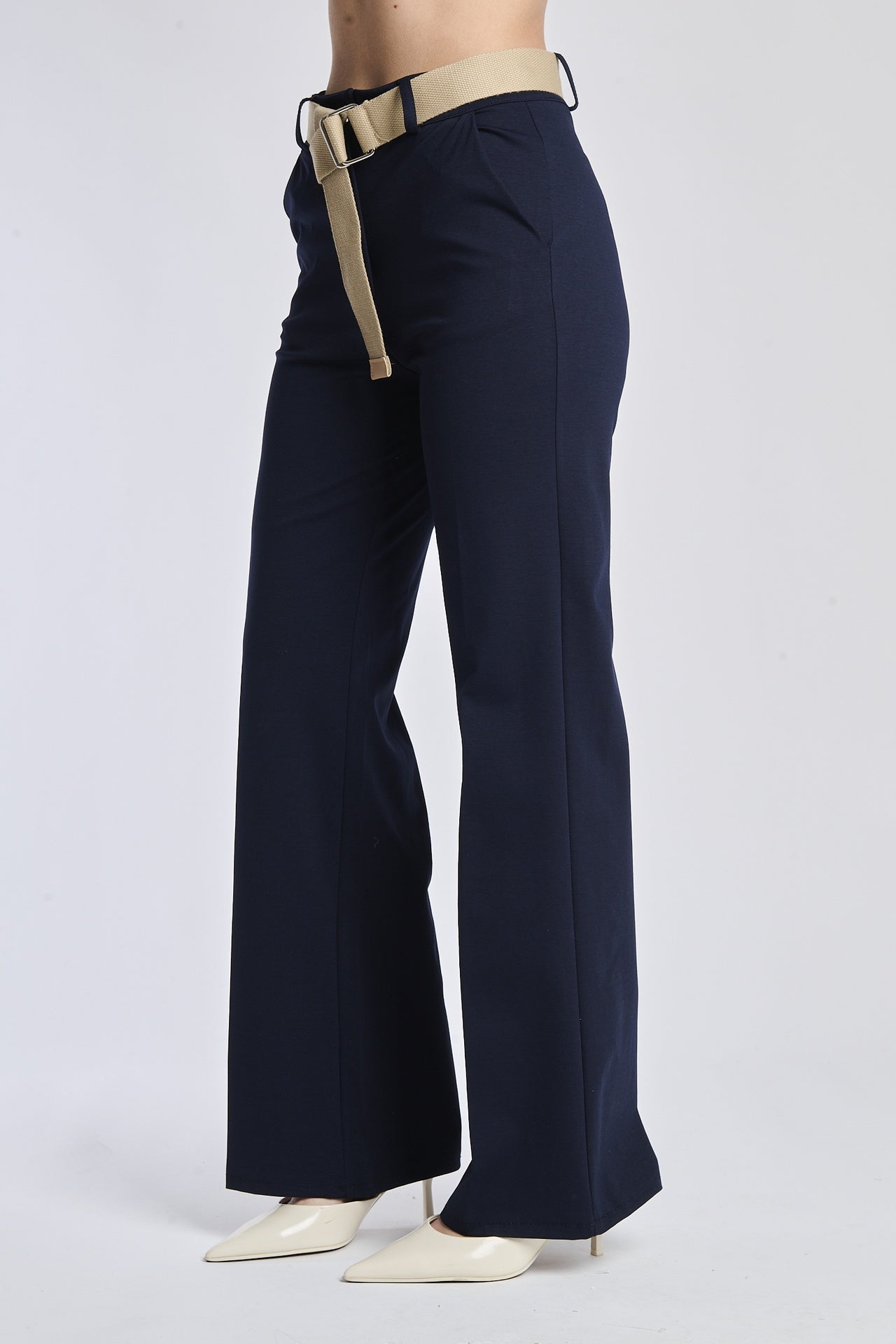 Pantaloni bianchi, cintura navy e sandali blu per un look estivo