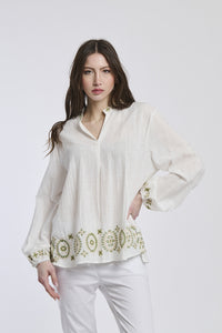 Donna con una giacca marrone di lana di taglio ampio, collo alto e maniche rimboccate, creando un look rilassato e accogliente, adatto per il tempo freddo.