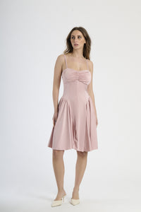 Donna con abito rosa antico a spalline, romanticismo e charme vintage.