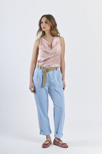 Look con top senza maniche rosa e pantaloni azzurri ampi, scarpe color cammello