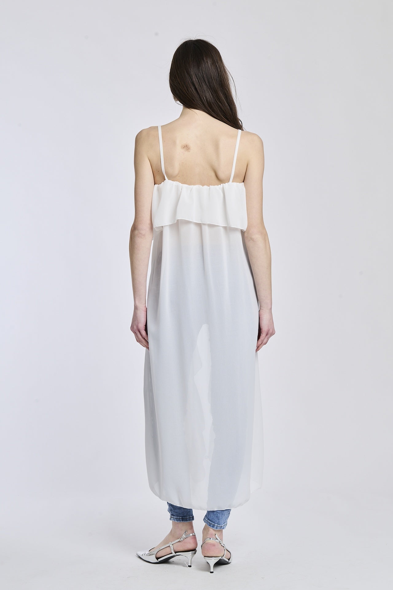 Top in bianco con un tessuto leggero e trasparente, che dona un look romantico e femminile.