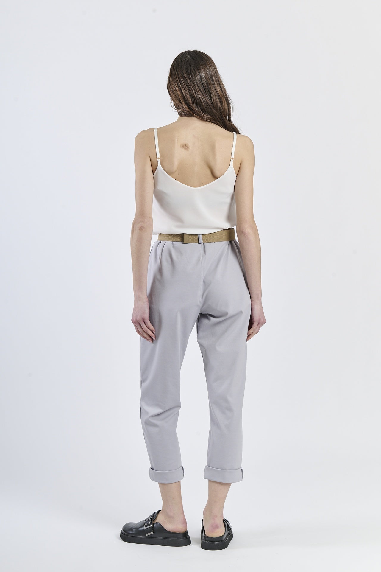 Combinazione top rosa lucido e pantaloni grigio chiaro, stile minimal-moderno
