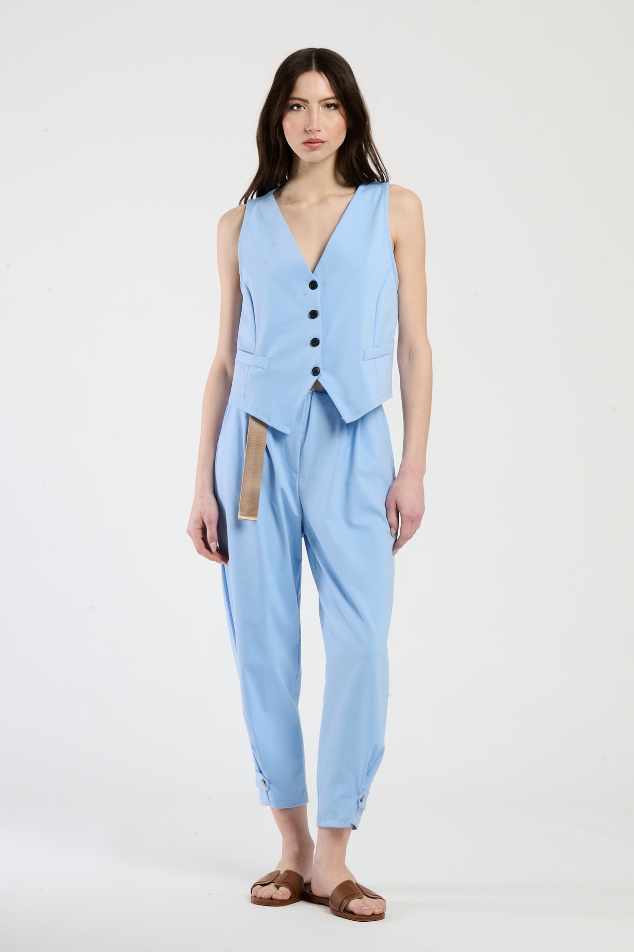 Modella in completo azzurro composto da gilet e pantaloni, perfetto per un look casual-chic.
