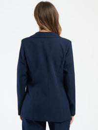 Outfit navy in tessuto liscio, blazer corto e pantaloni, perfetto per un look professionale.