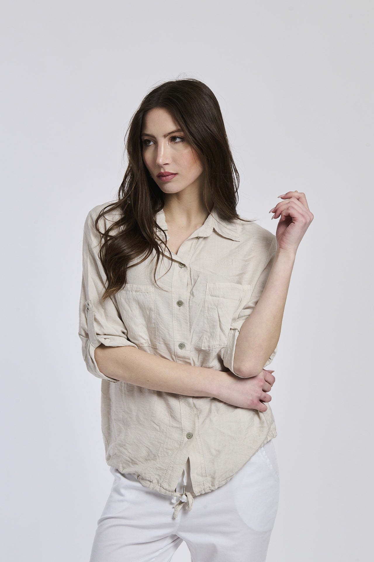Camicia beige da donna con cuciture minimaliste, che dona un’eleganza sobria.