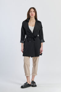 Trench nero con dettagli argento, contrasto elegante per eventi formali.