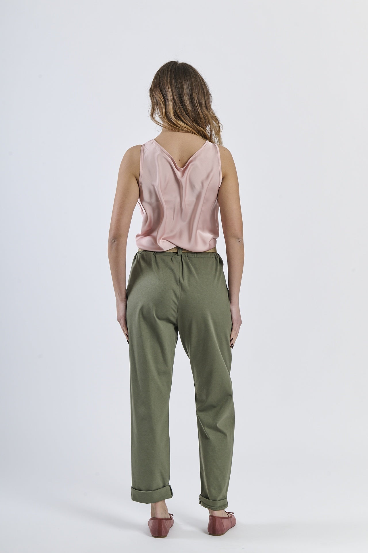 Combinazione top rosa lucido e pantaloni di colore verde militare, accento moderno